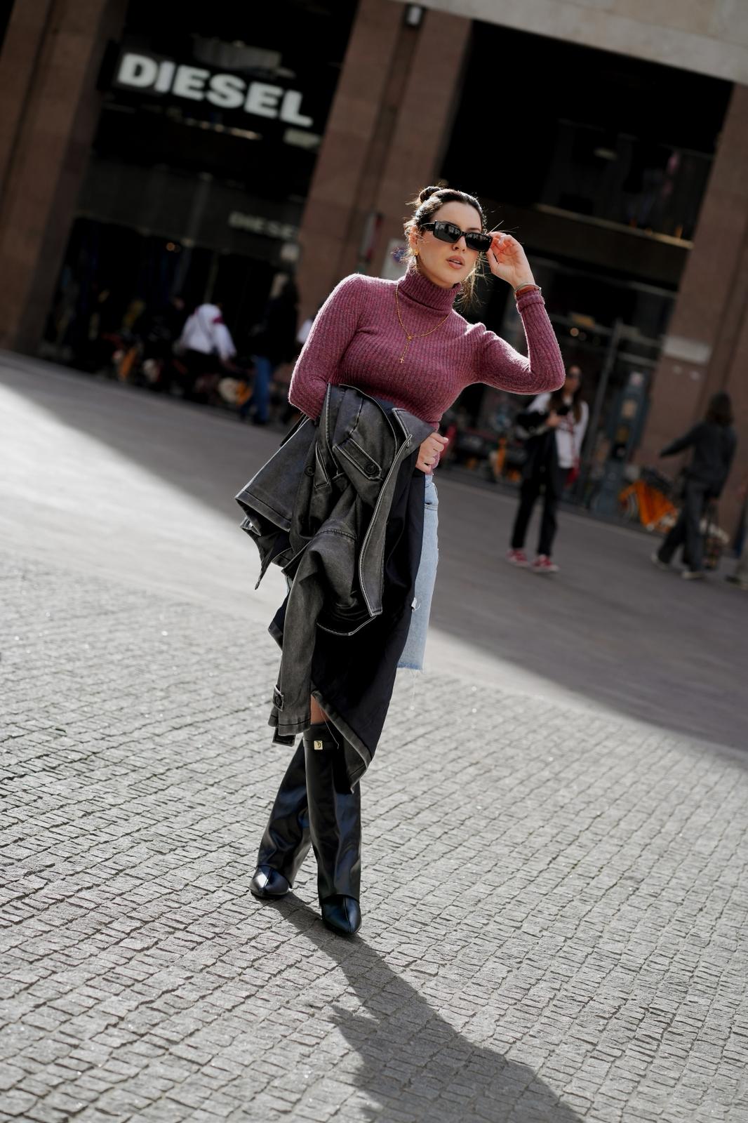 Gloria caminando por una plaza con suéter rosado