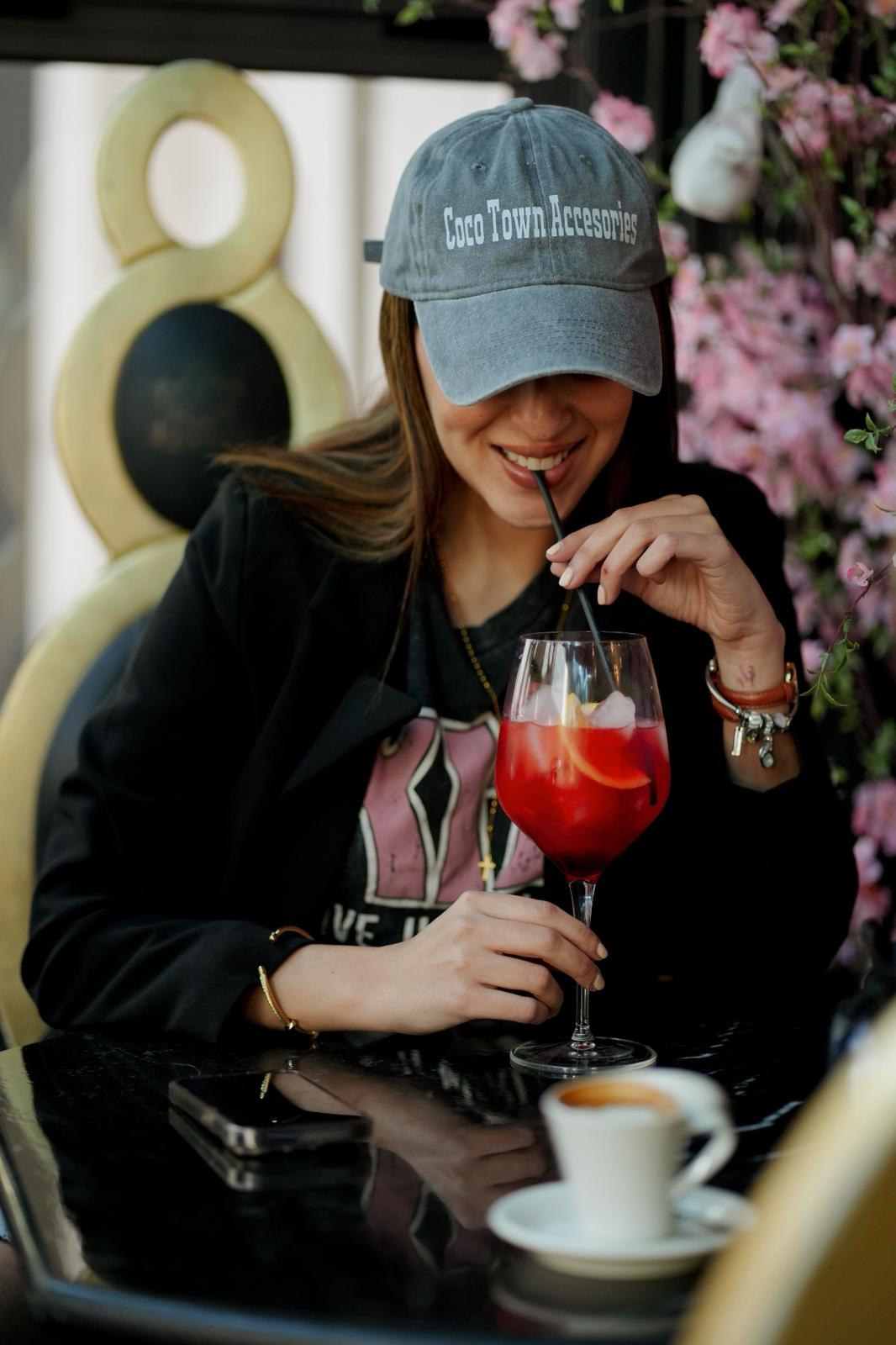 Gloria con gorra tomando un spritz en una terraza
